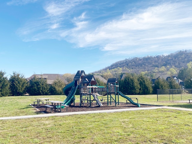 view of playground with a lawn and a mountain view