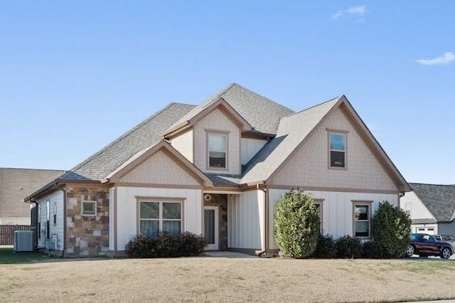 view of front of property with central AC and a front yard