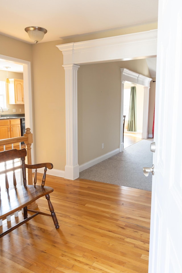 living area with sink and light hardwood / wood-style flooring