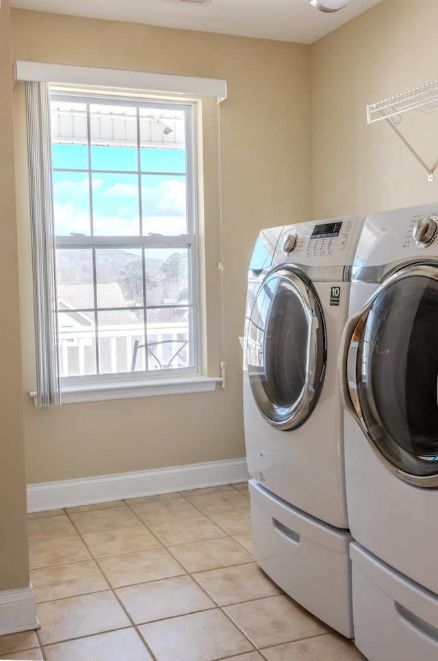 laundry room featuring washing machine and dryer and light tile patterned floors