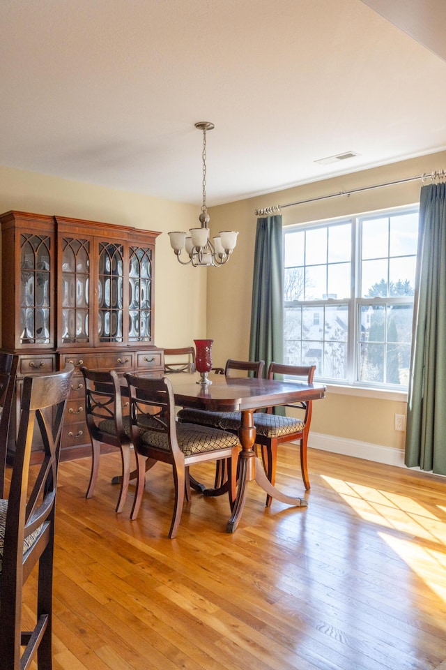 dining room featuring light hardwood / wood-style flooring and an inviting chandelier