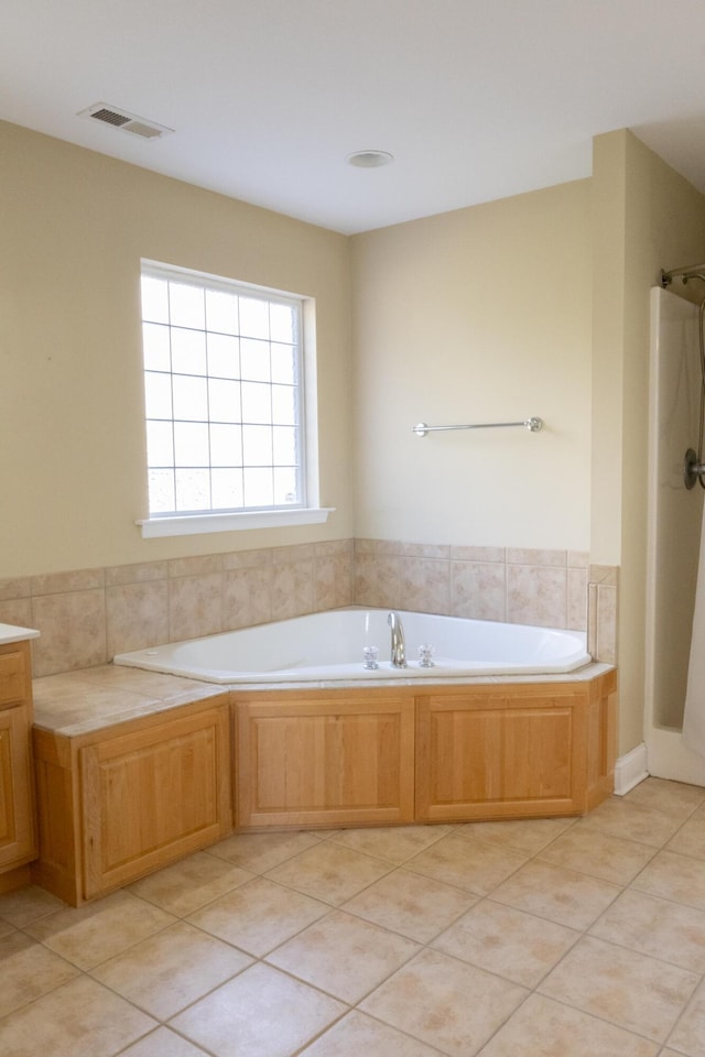 bathroom with tile patterned flooring, vanity, and a tub