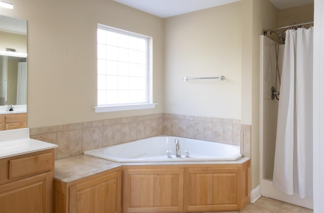 bathroom with shower with separate bathtub, vanity, and tile patterned floors