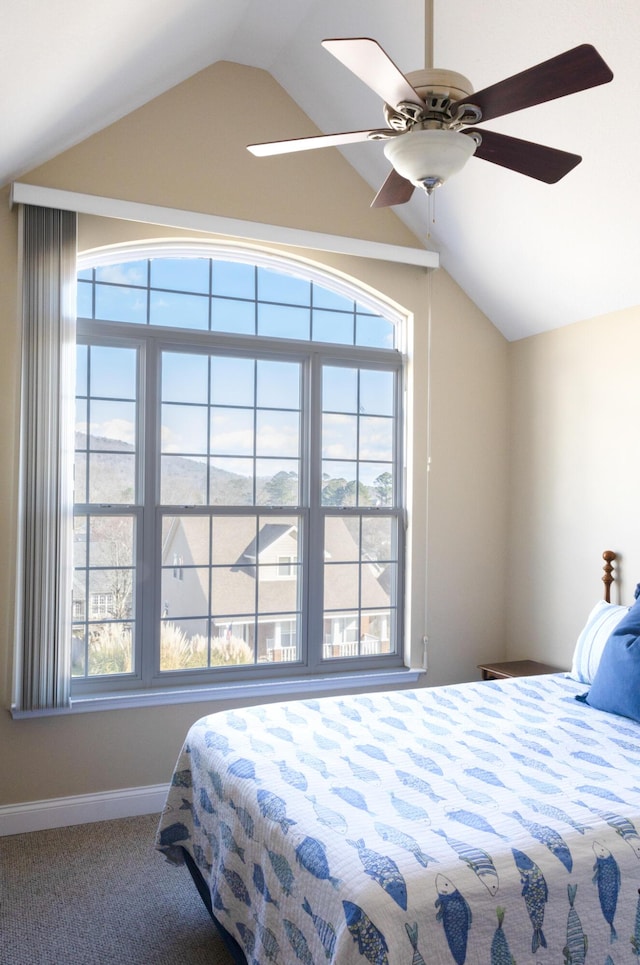 carpeted bedroom featuring multiple windows, vaulted ceiling, and ceiling fan