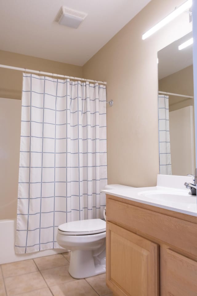 full bathroom with tile patterned flooring, vanity, shower / tub combo, and toilet