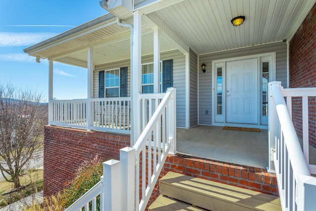 view of exterior entry featuring covered porch