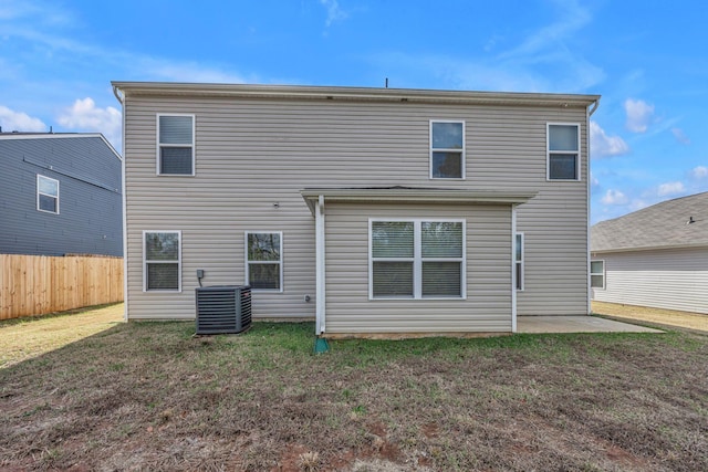 back of property featuring a lawn, central air condition unit, and a patio