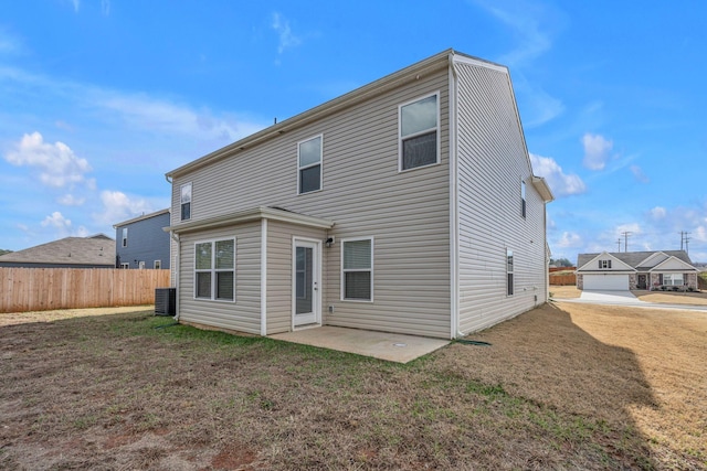 rear view of house featuring a lawn, a patio area, and central AC