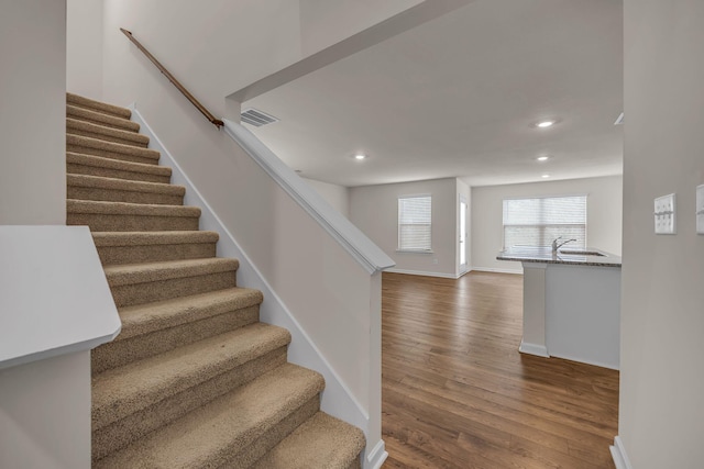 staircase with hardwood / wood-style floors