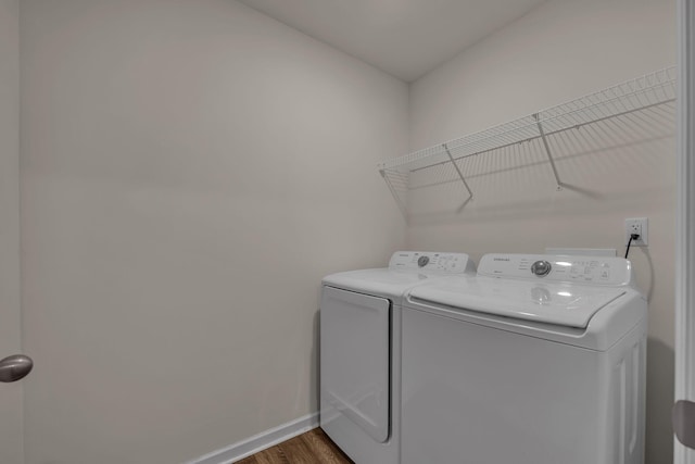 washroom with dark wood-type flooring and independent washer and dryer