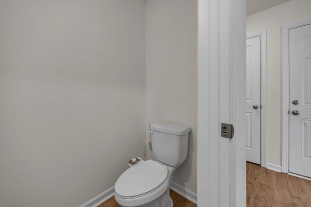 bathroom with hardwood / wood-style flooring and toilet