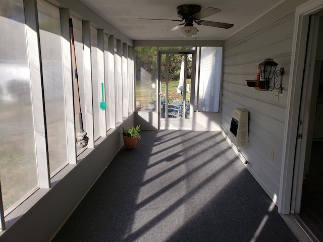 sunroom with heating unit and ceiling fan