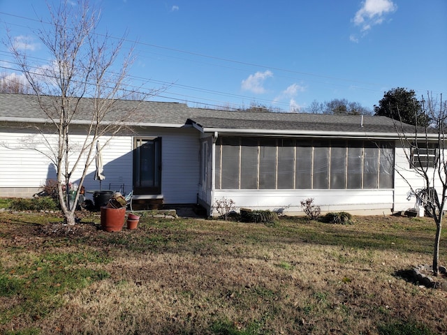 rear view of property with a sunroom and a yard