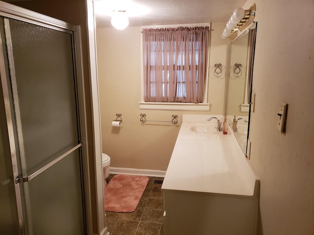 bathroom with vanity, toilet, and a shower with shower door