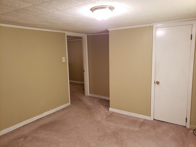 carpeted spare room featuring crown molding and a textured ceiling