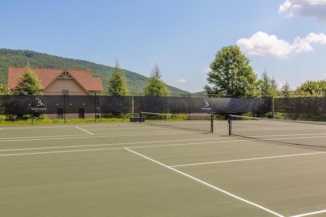 view of sport court featuring community basketball court, fence, and a mountain view