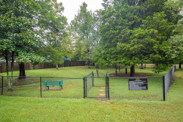 view of community with a gate, fence, and a lawn