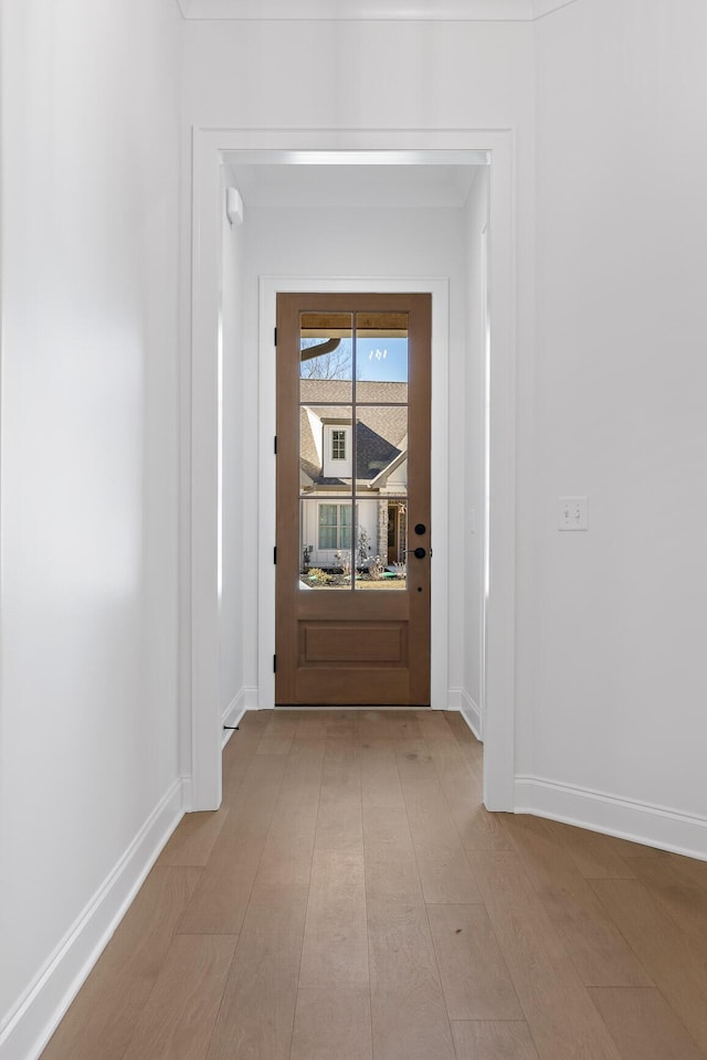 doorway with light wood-style flooring and baseboards