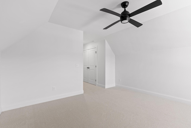 bonus room with light carpet, vaulted ceiling, a ceiling fan, and baseboards