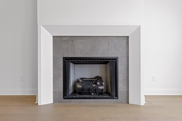 interior details with a fireplace, wood finished floors, and baseboards