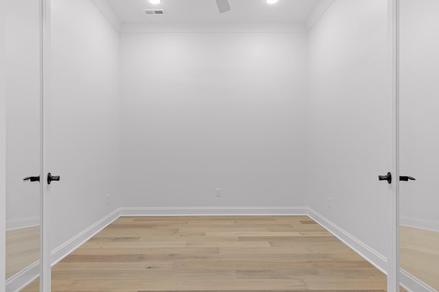 unfurnished room with baseboards, light wood-style flooring, visible vents, and crown molding