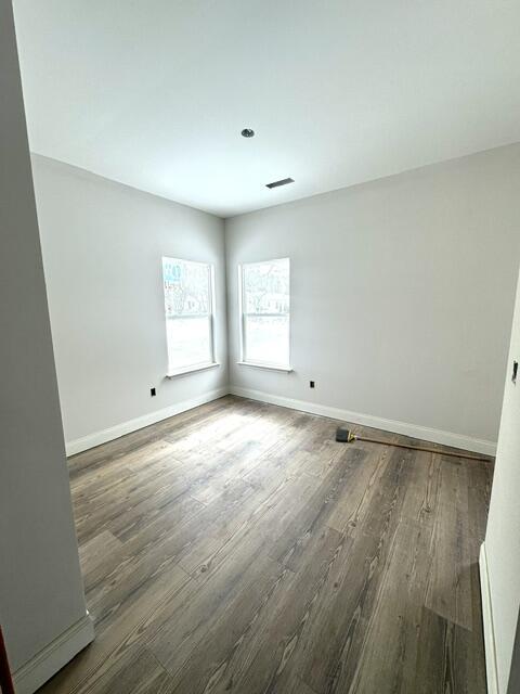 unfurnished room with dark hardwood / wood-style flooring