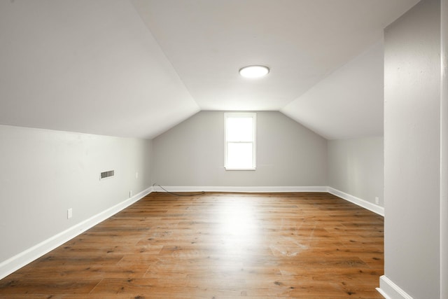 bonus room with wood-type flooring and lofted ceiling