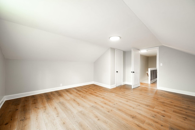 bonus room with light wood-type flooring and lofted ceiling