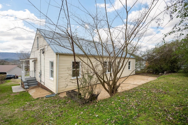 view of property exterior with a patio area and a yard