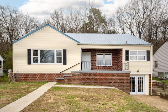 view of front of home with a front yard, french doors, and central AC