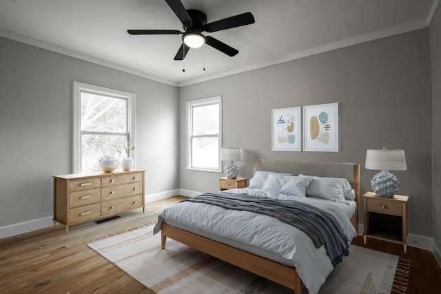 bedroom with light wood-type flooring, ceiling fan, and ornamental molding