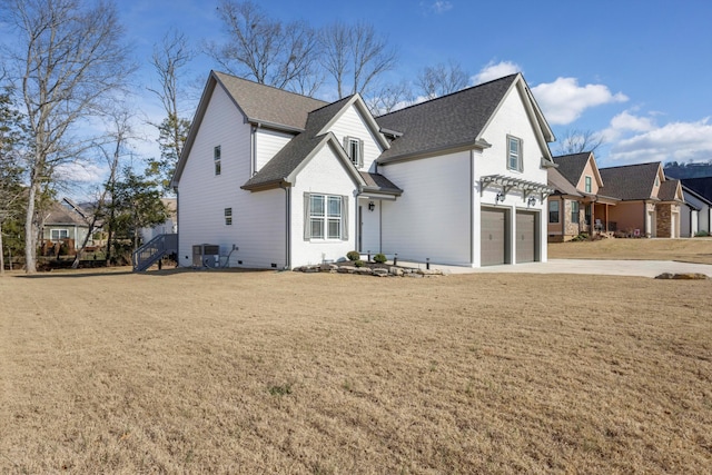 front facade with cooling unit, a garage, and a front lawn