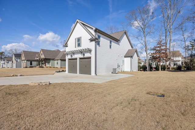 view of property exterior featuring a lawn, cooling unit, and a garage