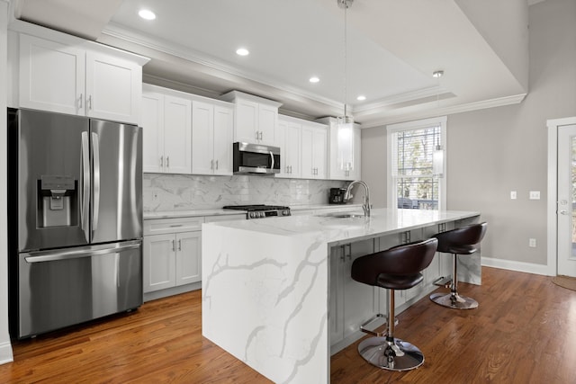 kitchen featuring white cabinetry, sink, an island with sink, and appliances with stainless steel finishes