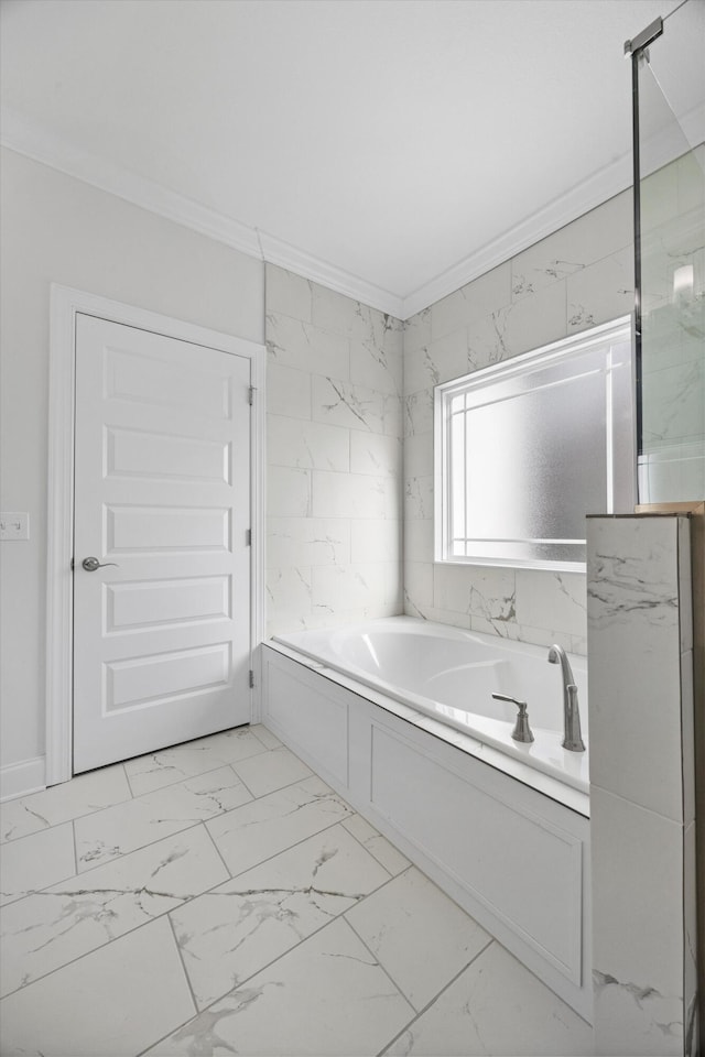 bathroom with ornamental molding and a bath