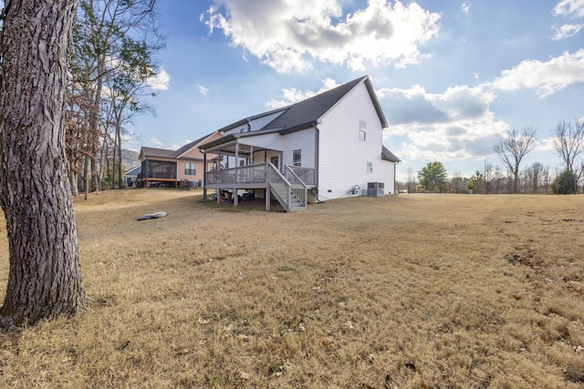 back of property featuring central air condition unit, a lawn, and a wooden deck