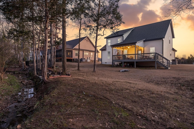 back house at dusk with a wooden deck