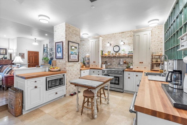 kitchen with wood counters, stainless steel appliances, and white cabinets