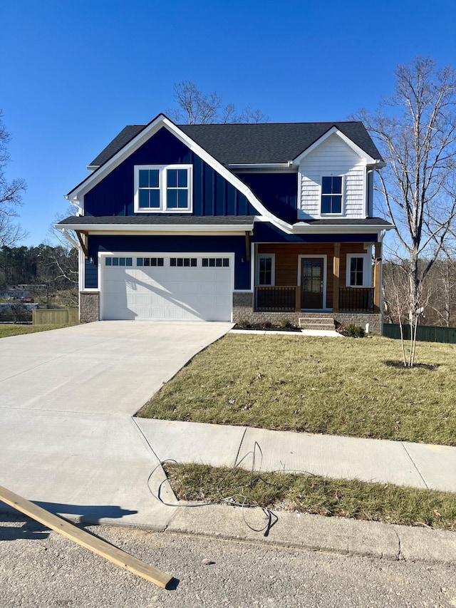 view of front of property featuring a front lawn, a porch, and a garage