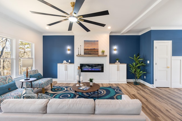 living room featuring a fireplace, ceiling fan, hardwood / wood-style floors, and crown molding