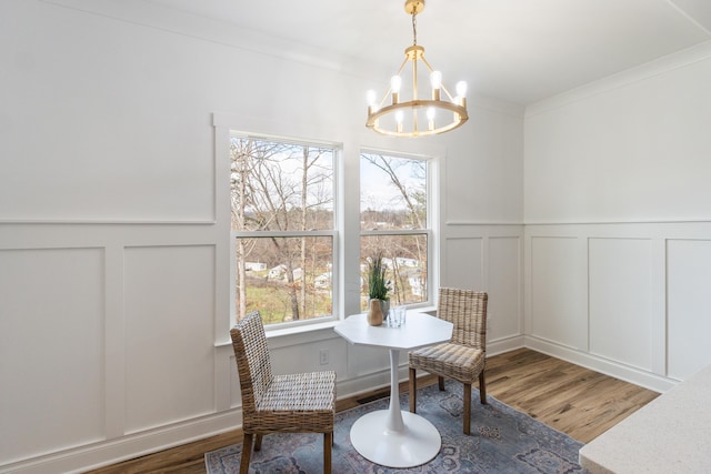 sitting room with ornamental molding, an inviting chandelier, and dark wood-type flooring