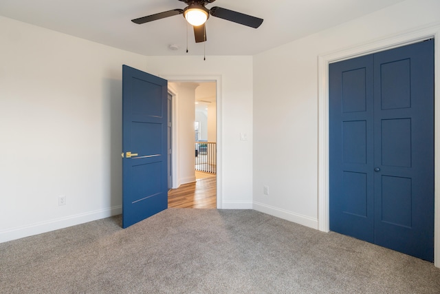 unfurnished bedroom featuring carpet flooring, ceiling fan, and a closet