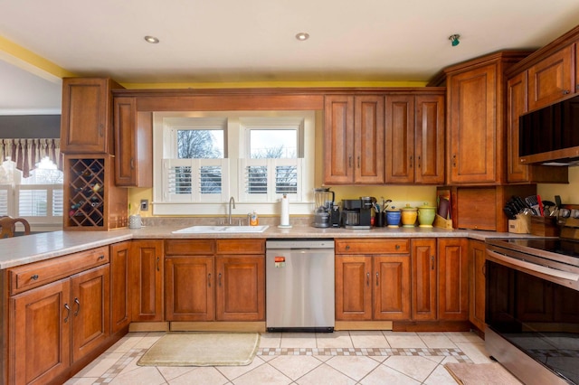 kitchen with appliances with stainless steel finishes, light tile patterned floors, and sink