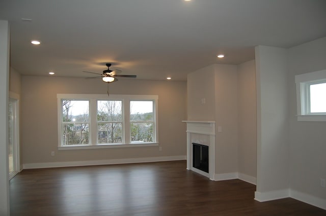 unfurnished living room featuring ceiling fan and dark hardwood / wood-style floors