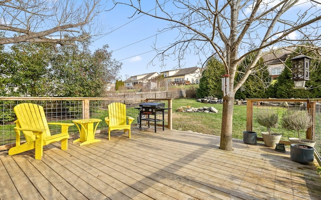 wooden deck with a lawn and area for grilling