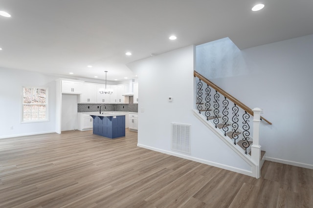 living room featuring sink and light hardwood / wood-style flooring