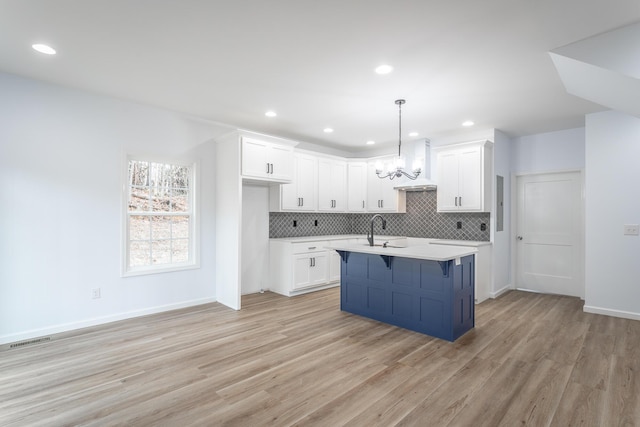 kitchen with white cabinetry, sink, and hanging light fixtures