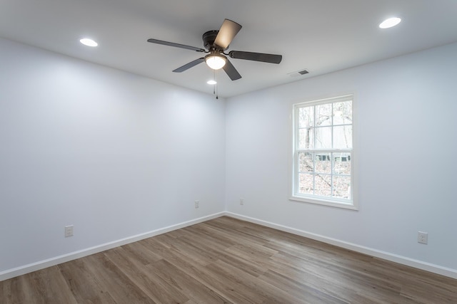 spare room featuring wood-type flooring and ceiling fan