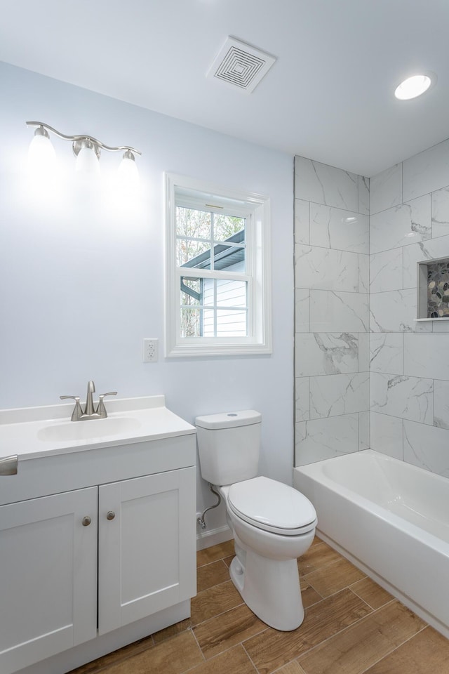 full bathroom featuring toilet, vanity, and tiled shower / bath combo