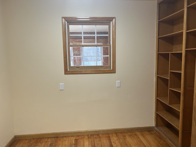 empty room featuring baseboards and wood finished floors